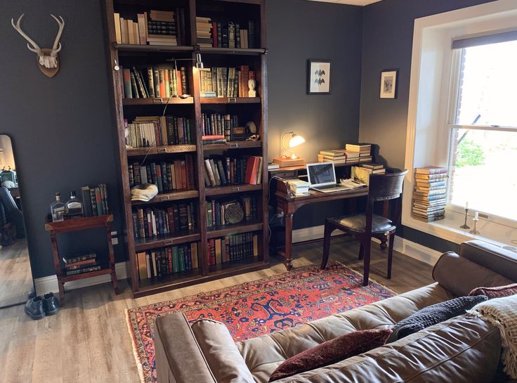 a living room filled with furniture and bookshelves next to a large open window