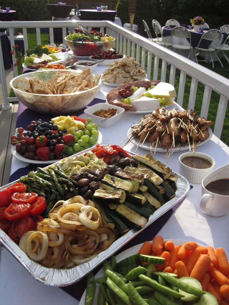 a long table filled with lots of food on top of a white table cloth covered in plates and bowls