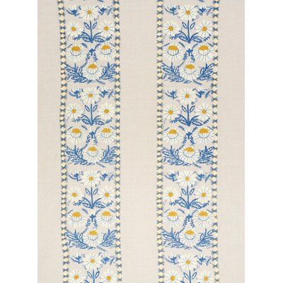 an embroidered white and blue wallpaper with flowers on the border, in front of a white background