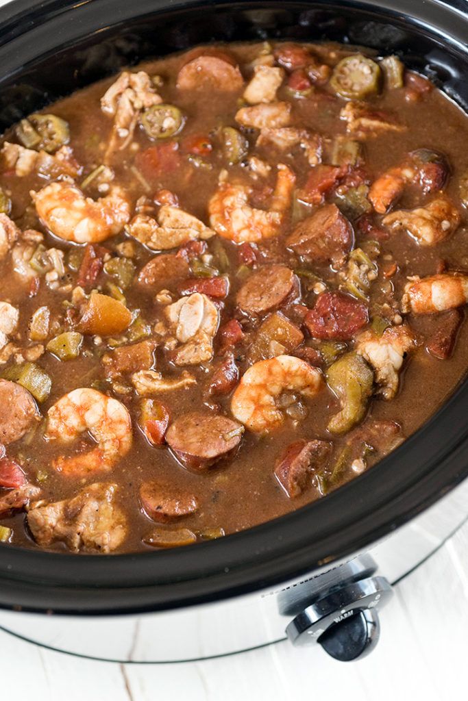 a crock pot filled with shrimp and vegetables