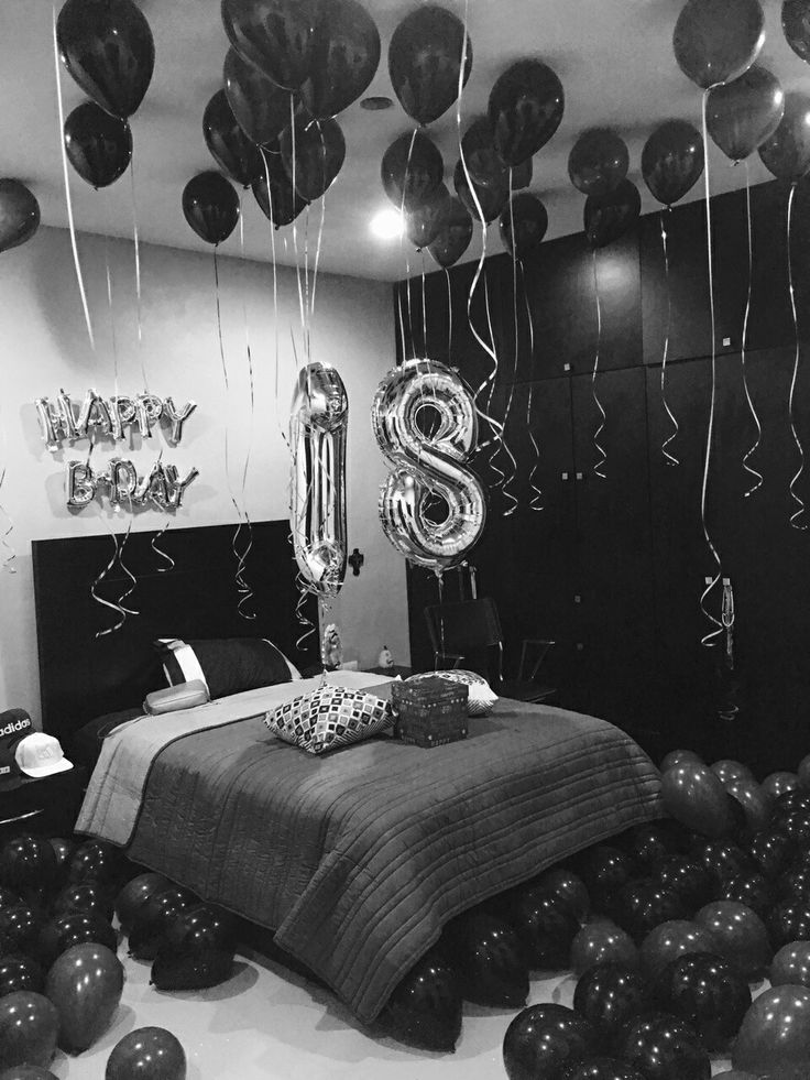 black and white photograph of a bedroom with balloons