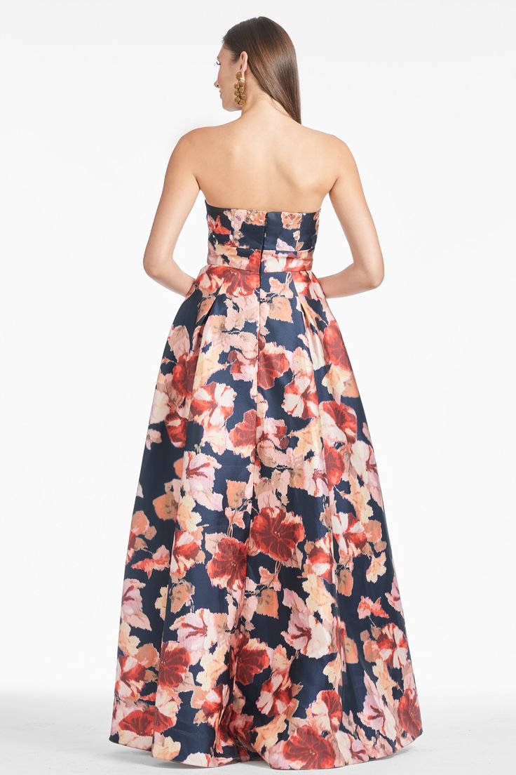 a woman wearing a strapless dress with floral print on the skirt and back view