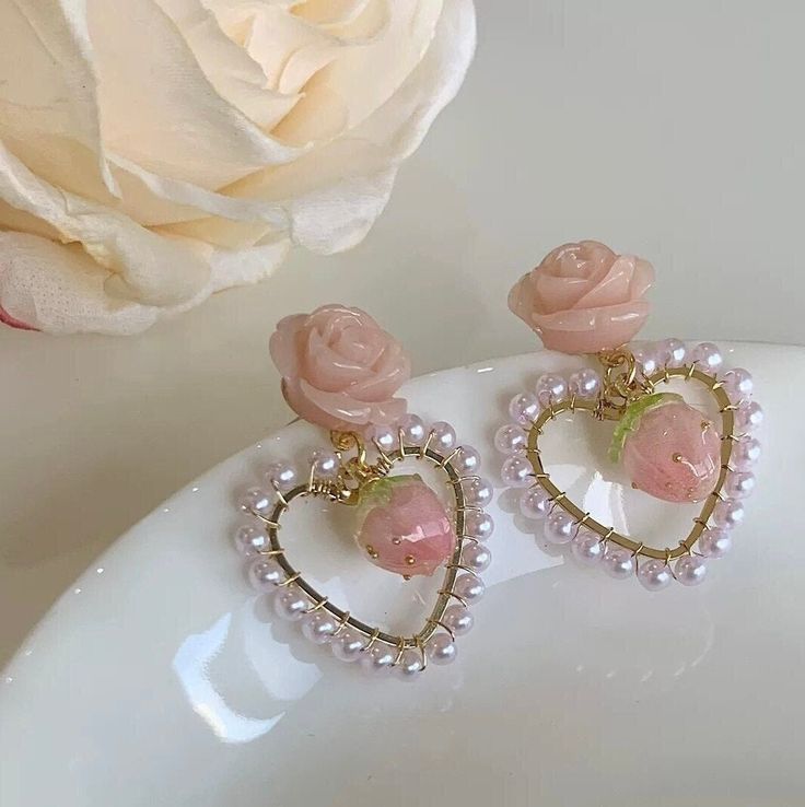 Cutest wild rose floral stud earrings with pastel pink baby strawberry drop and pearl beaded heart shaped hoop dangle. Super adorable accent, girly pinky dreamy vibes. A pair of handmade delicate unique earrings. Perfect gift for girls, a little cute spice to elevate your style! 💎 Features: ♥ Handcrafted Earrings ♥ Material: gold plated sterling silver ♥ Main stone: cultured pearl bead, resin, acrylic ♥ Push Closure 💎 Details: ♥ Approximate Measurements: - Length: 1.5 inches - Width: 1 inches Heart Shaped Pearl Earrings, Aesthetic Items, Pink Gift Ideas, Coquette Core, Strawberry Earrings, Beaded Heart, Diy Collier, Romantic Heart, Floral Studs