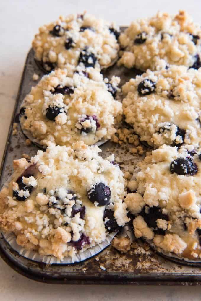 blueberry crumb muffins on a baking sheet