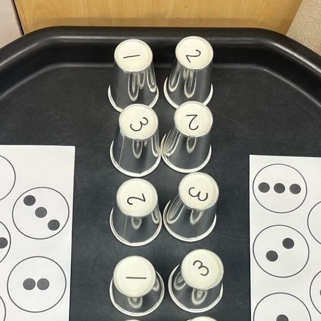 a tray that has some cupcakes on it and two cups with faces in them