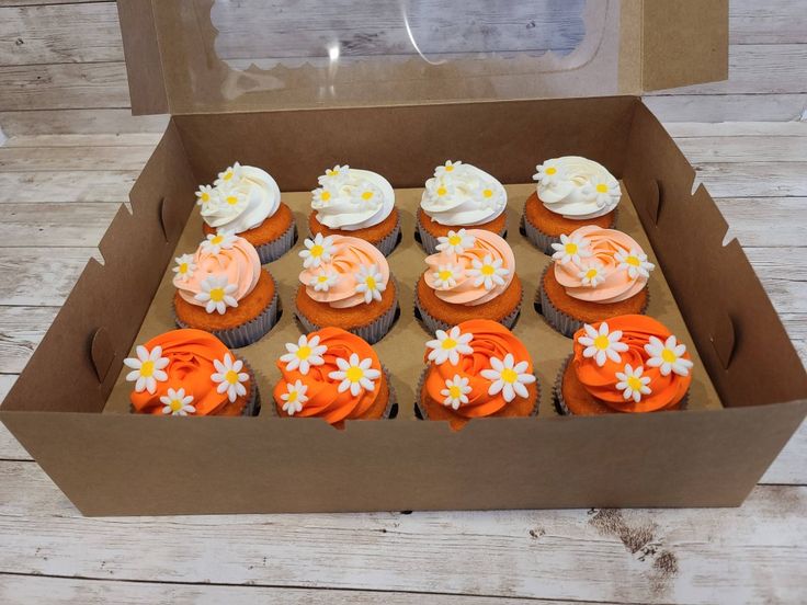 a box filled with cupcakes covered in frosting