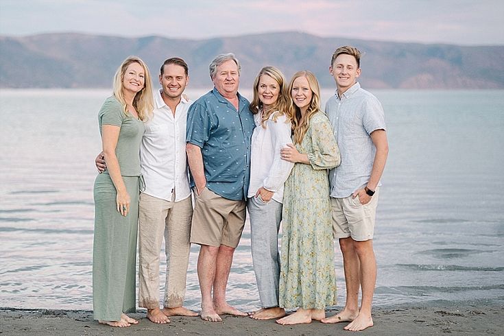 a group of people standing next to each other on a beach