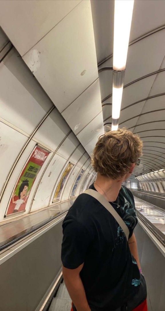 a man standing on an escalator in a subway