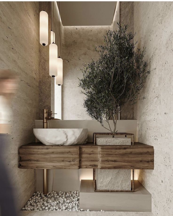 a bathroom with a sink, mirror and plant on the counter in front of it