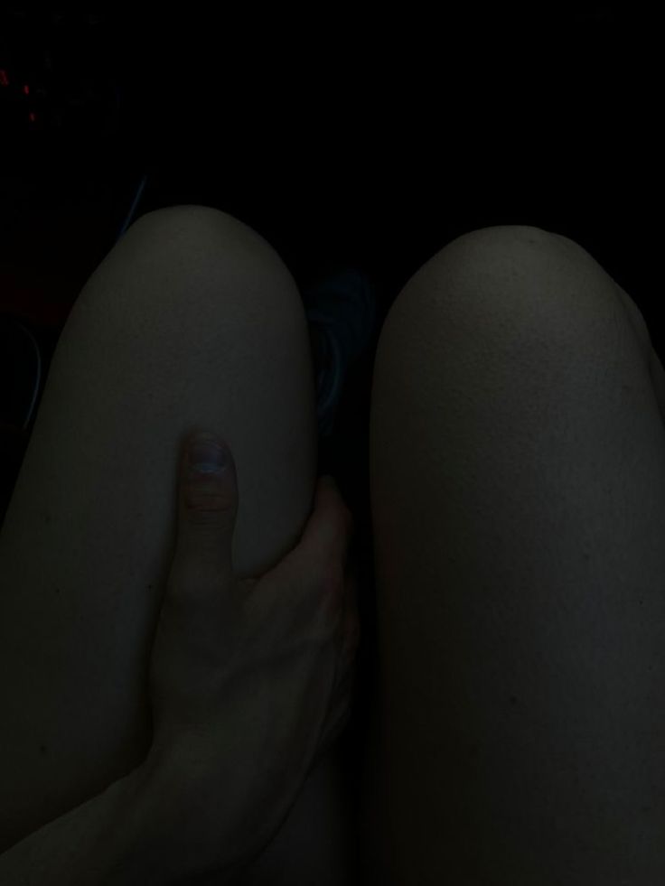 a person laying down in the dark with their legs crossed