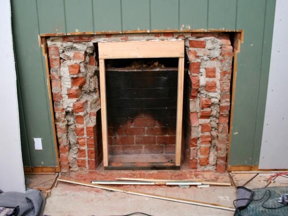 a brick fireplace being built in the corner of a room