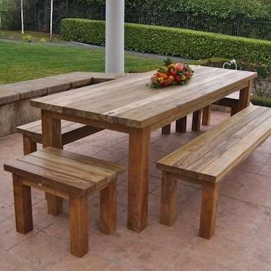 a wooden picnic table with two benches on the side and a basket of fruit on top