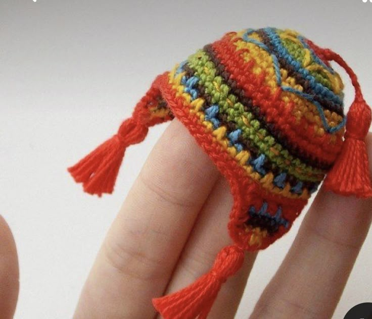 a hand holding a small knitted toy fish