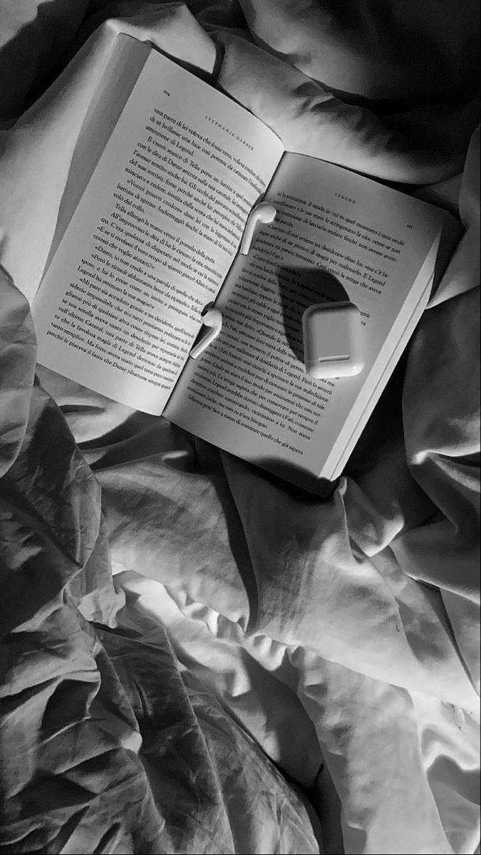 an open book sitting on top of a bed