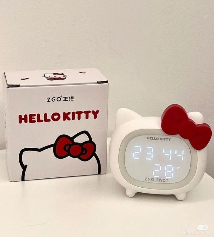 a hello kitty alarm clock next to a box with the word hello kitty on it