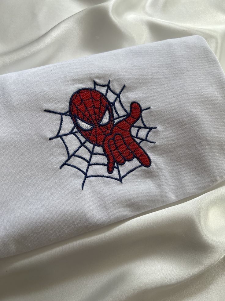 a spiderman embroidered on top of a white sheet