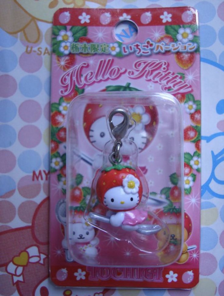 a hello kitty keychain with a strawberry on it's back in a package