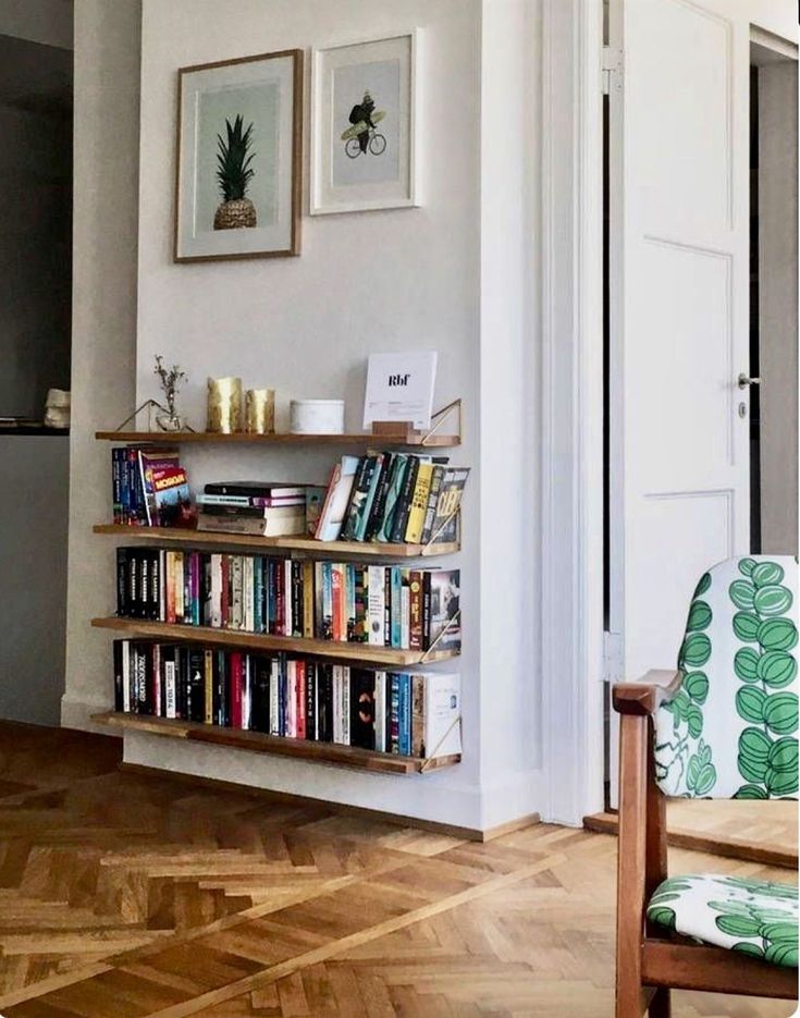 a book shelf filled with lots of books in a living room next to a doorway