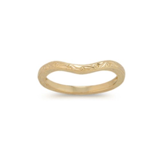 a gold wedding band with an intricate design