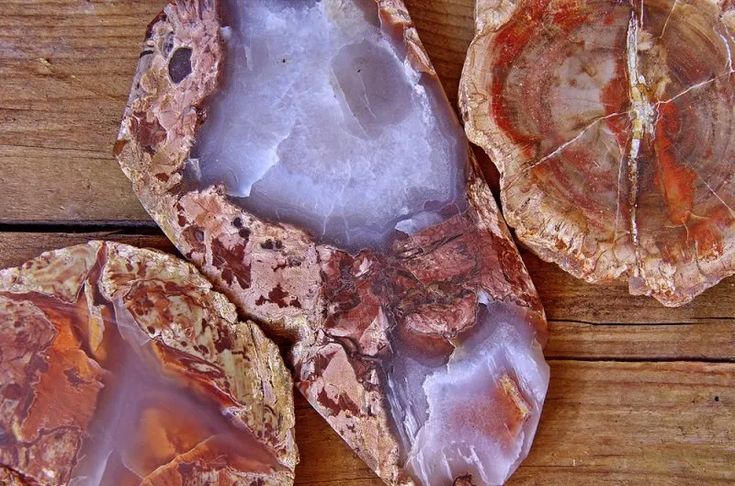 three pieces of rock sitting on top of a wooden table