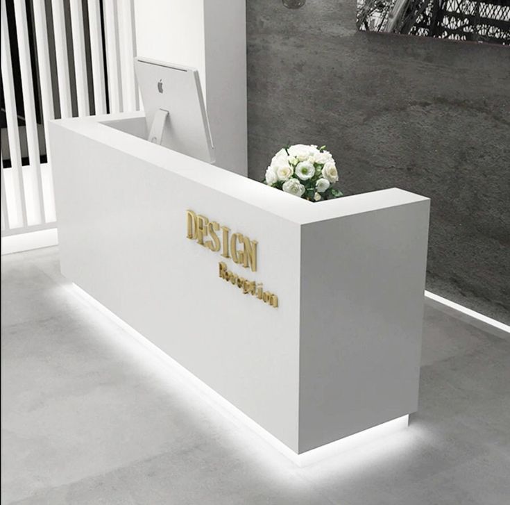 a white marble reception desk with flowers on it and the word design written in gold