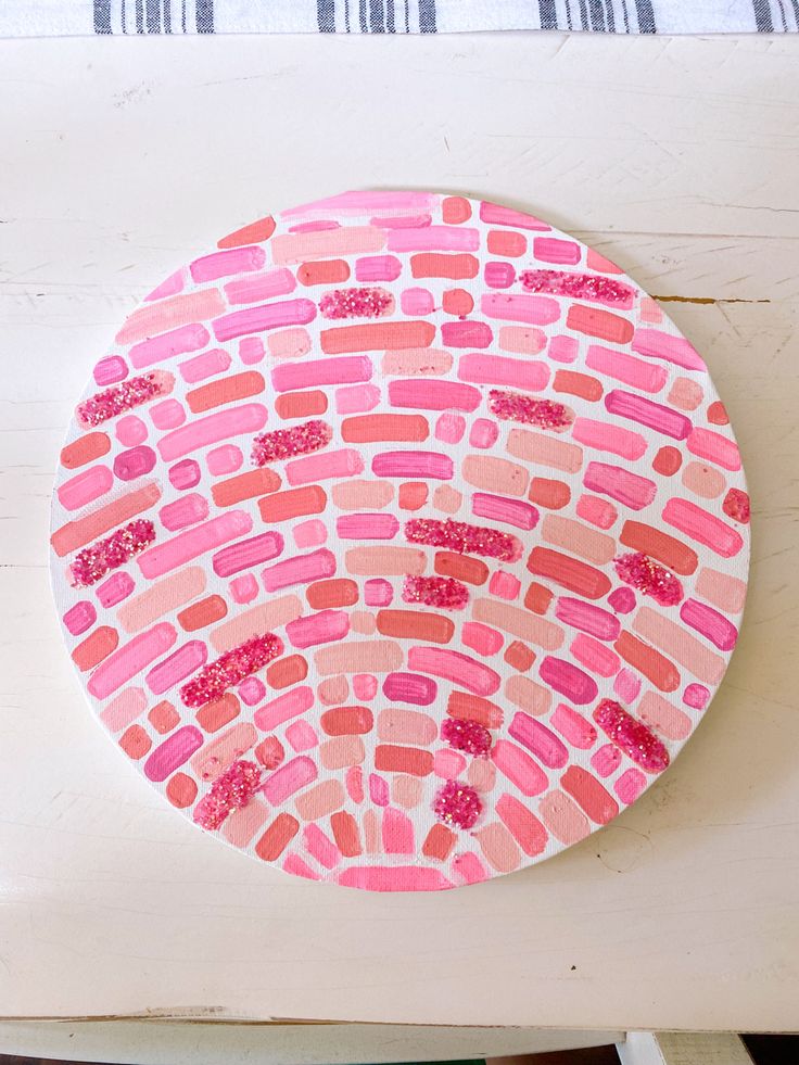 a paper plate with pink and red designs on it sitting on top of a table