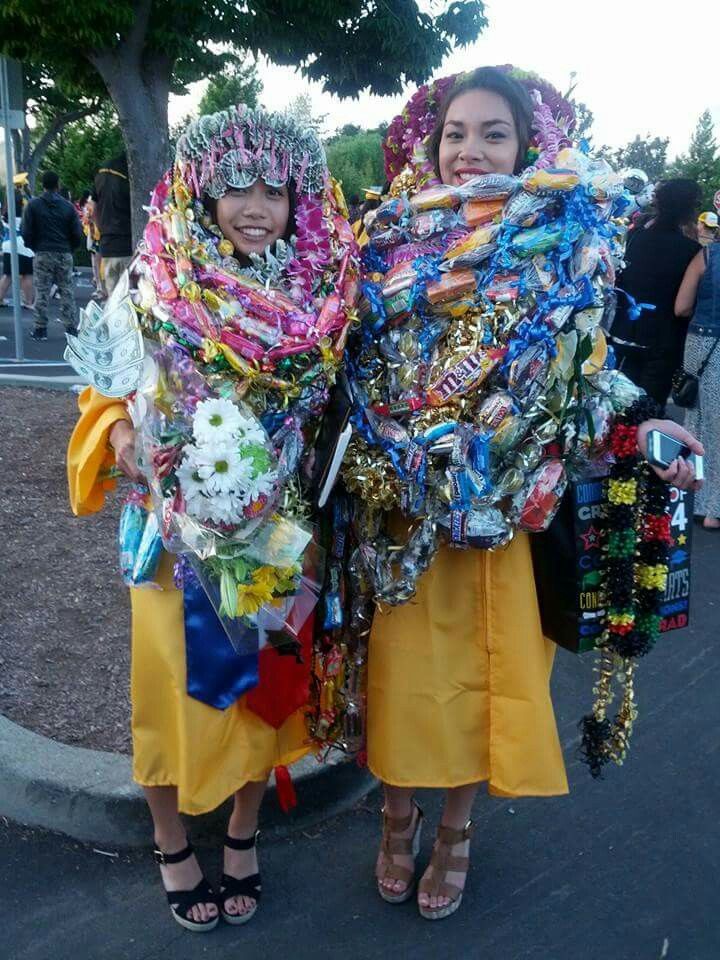 two women dressed in colorful clothing and headdresses holding bouquets of flowers