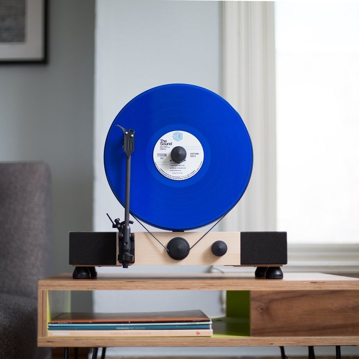 a blue record player sitting on top of a wooden table