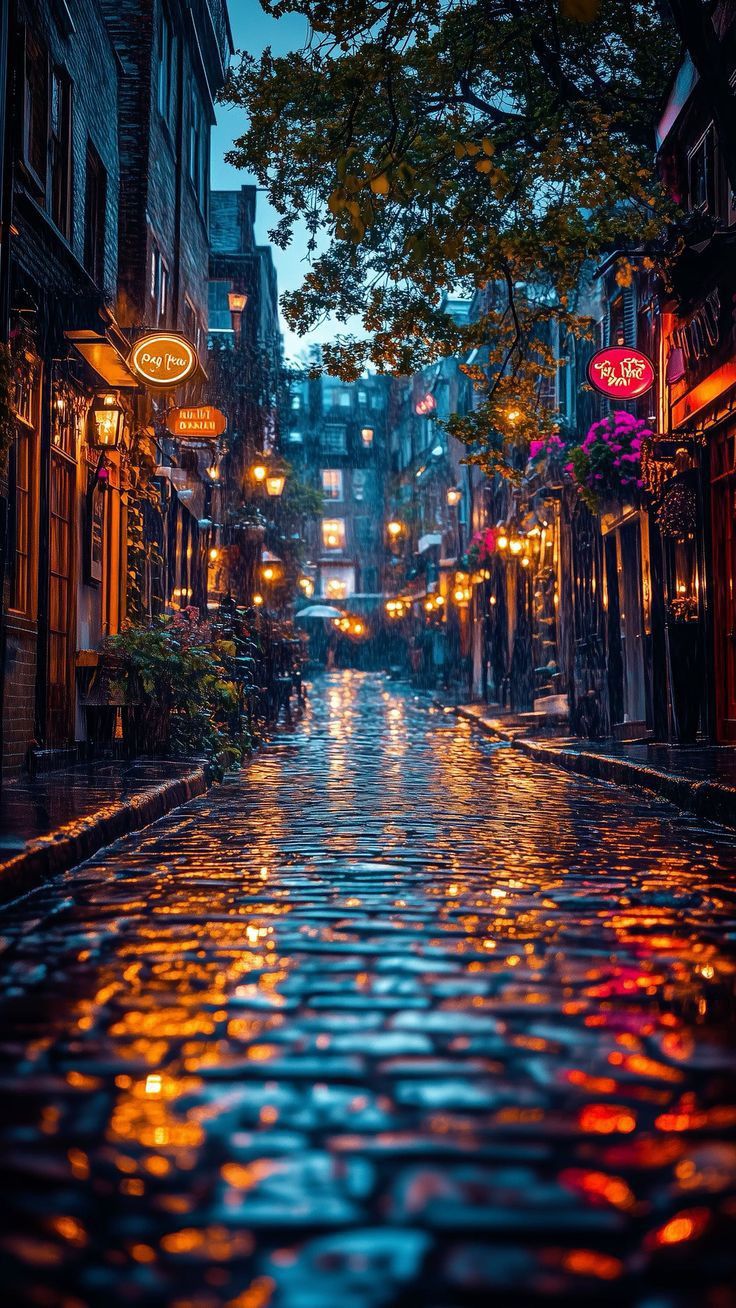 an empty city street at night with lights reflecting off the wet pavement and buildings on both sides