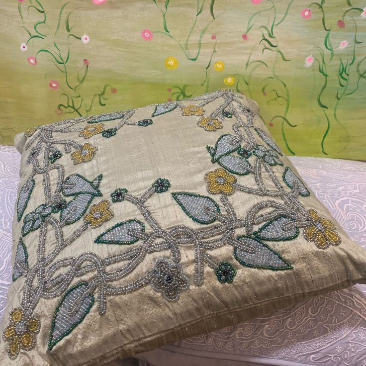 a decorative pillow sitting on top of a white table next to a green and yellow wall