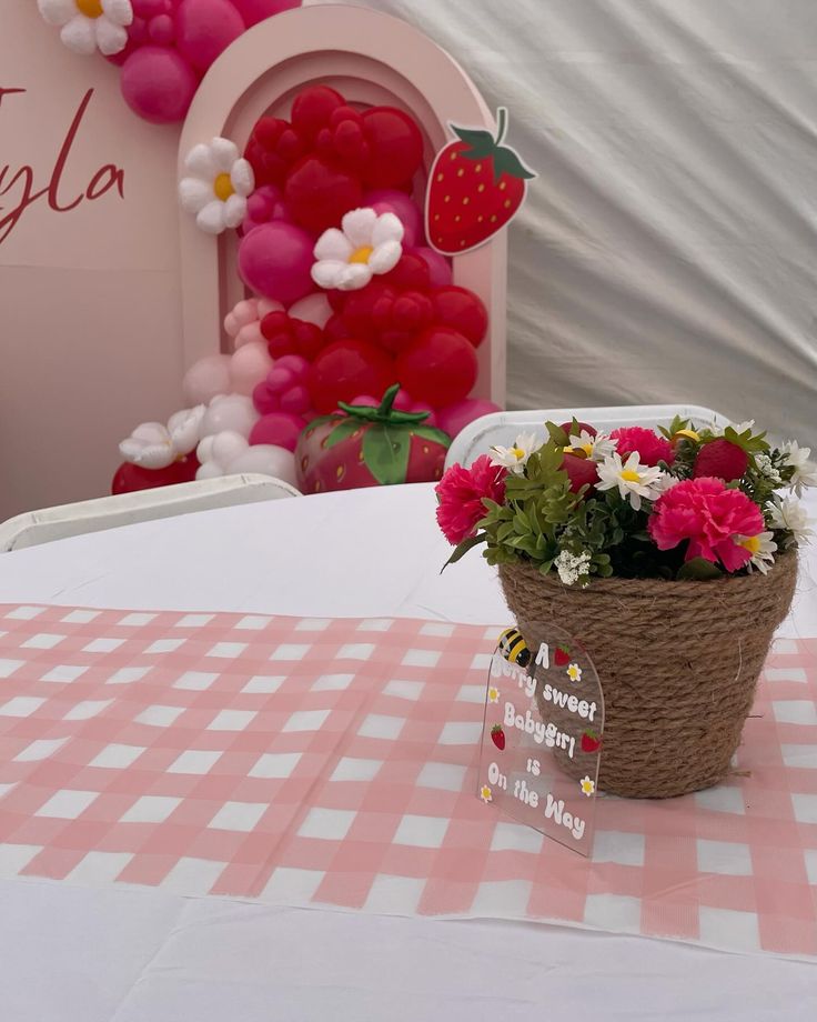 a basket filled with flowers sitting on top of a checkered tablecloth covered table