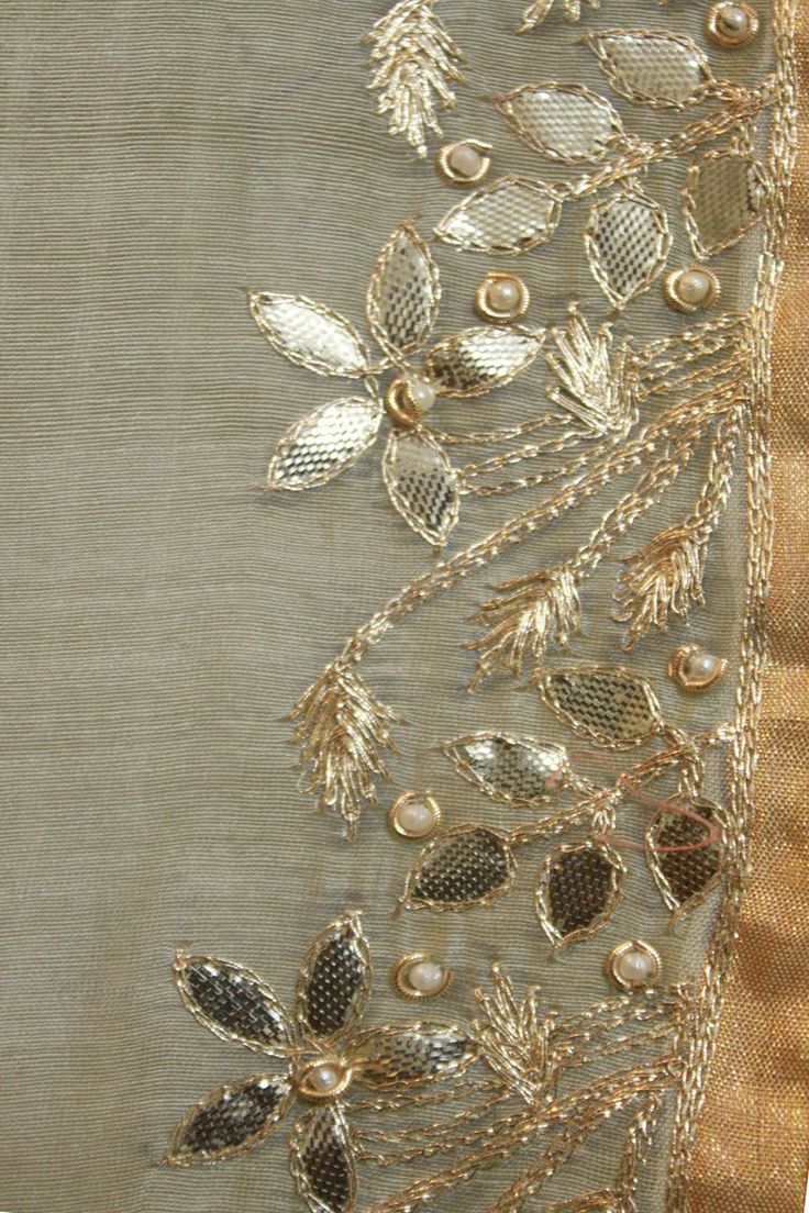 a piece of cloth with gold thread and beads on it