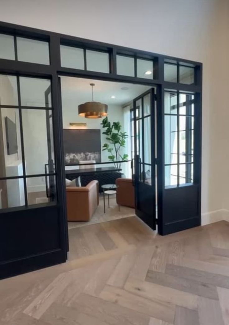 an open door leading to a living room and dining area with wood flooring on the side