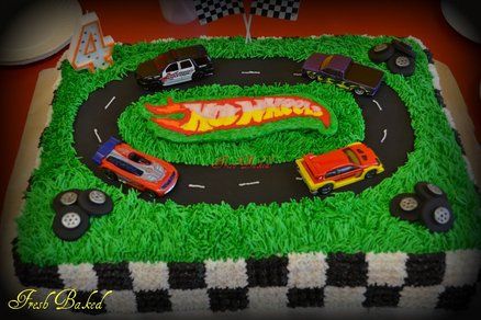 a birthday cake made to look like a race track with cars and trucks on it