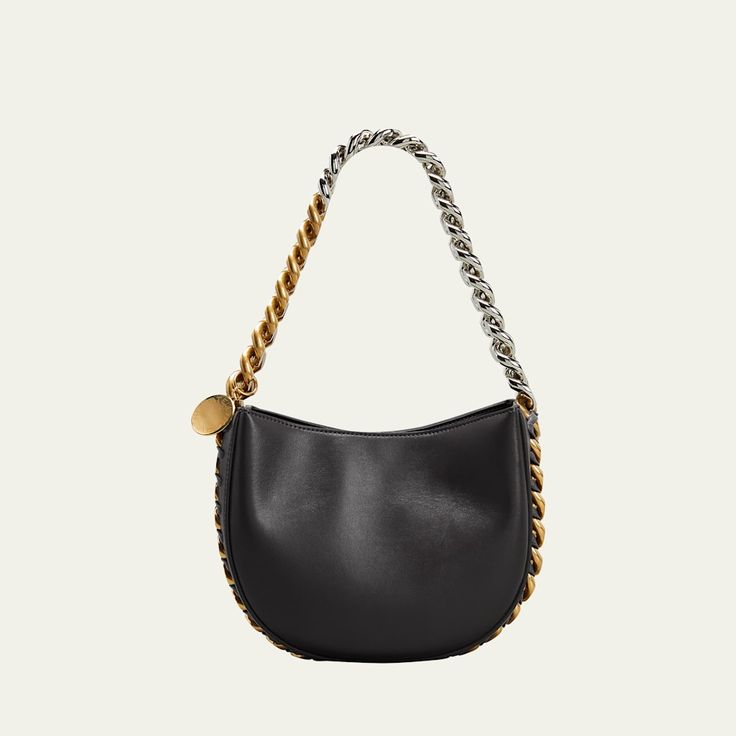 Stella McCartney shoulder bag in faux-leather. Two-tone chain shoulder strap woven onto bag; hanging engraved charm. Detachable, adjustable shoulder strap, 22.6" drop. Open top with snap closure. Interior, one slip pocket. Approx. 6.9"H x 8.5"W x 2.8"D. Item weighs approx. 1.9 lb. "Frayme" is made in Italy. Stella Mccartney Frayme, Stella Mccartney Falabella, Cable Stitch, T Strap Sandals, Small Crossbody Bag, Small Crossbody, Black Cross Body Bag, Open Top, T Strap