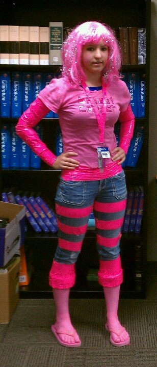 a woman in pink and grey striped pants standing next to a book shelf filled with books