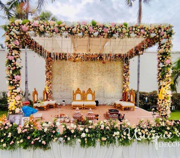 an outdoor stage decorated with flowers and greenery