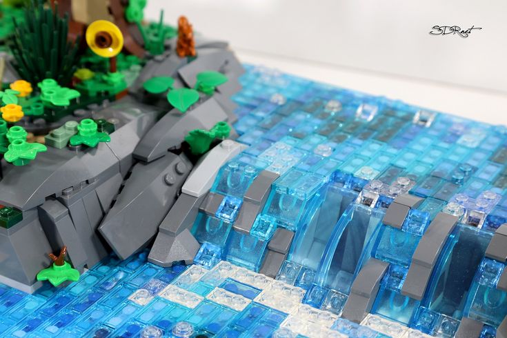 a close up of a lego model with blue and green tiles on the ground next to it