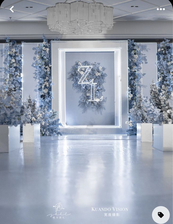 a white room decorated with blue flowers and greenery for an elegant wedding ceremony or special event