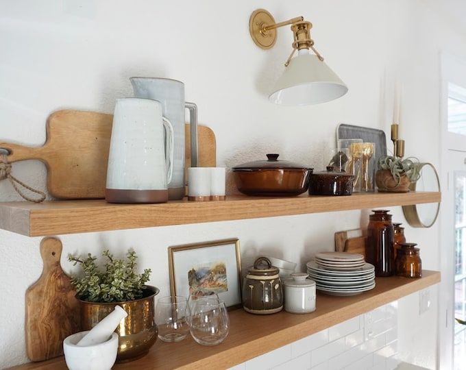 the shelves are filled with dishes and cups