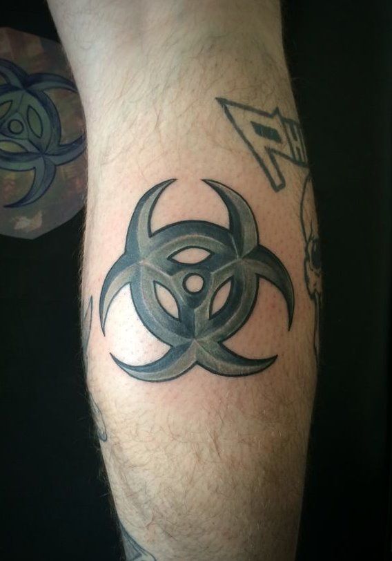 a man with a tattoo on his leg has a biohazard symbol on it