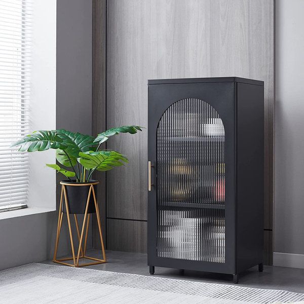 a black cabinet next to a potted plant