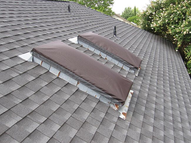 two flat roof vents on top of a house