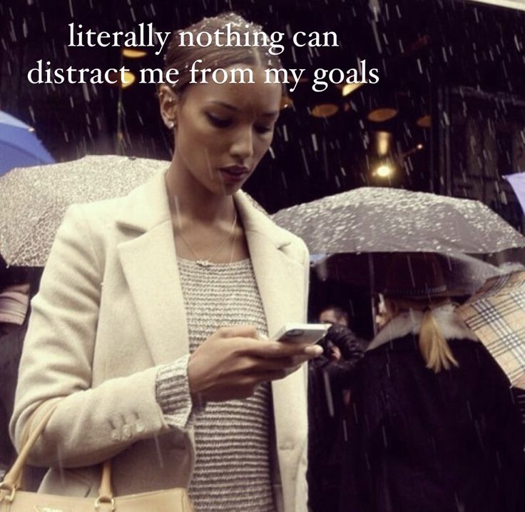 a woman standing in the rain holding an umbrella and looking at her cell phone with a quote on it