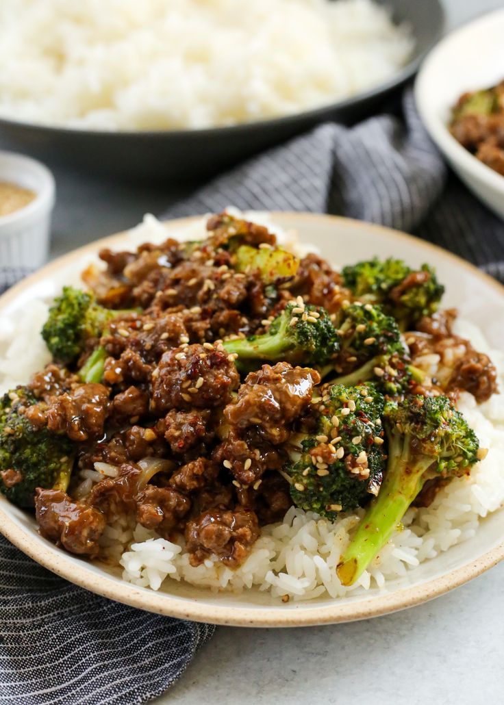 a white plate topped with rice and broccoli covered in ground beef on top of it