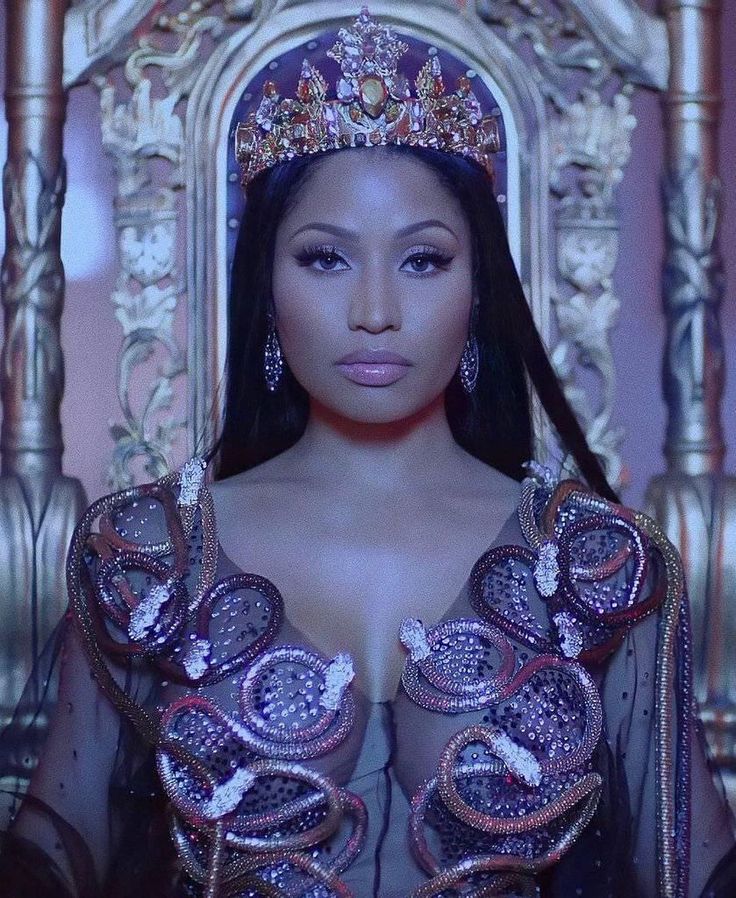 a woman wearing a tiara sitting on a chair in front of a gold throne