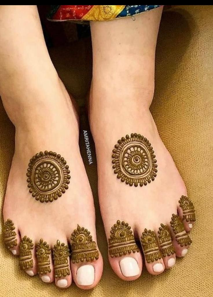 two feet with henna tattoos on them and one foot in the shape of a circle