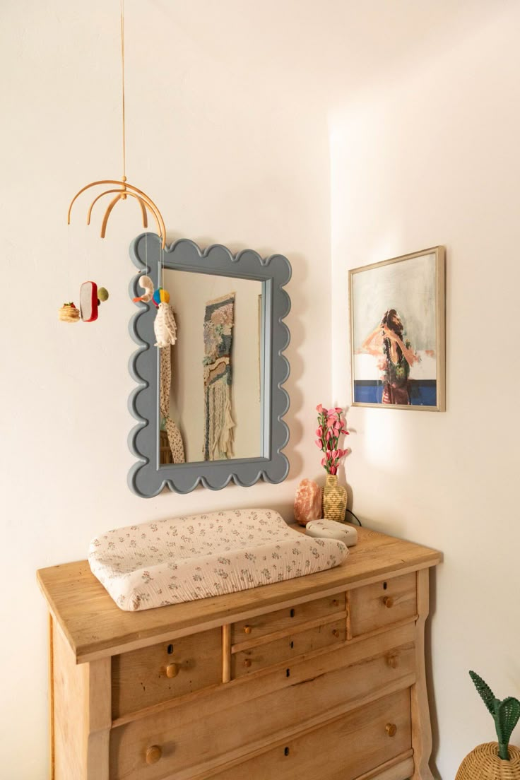 a baby crib in the corner of a room next to a dresser and mirror