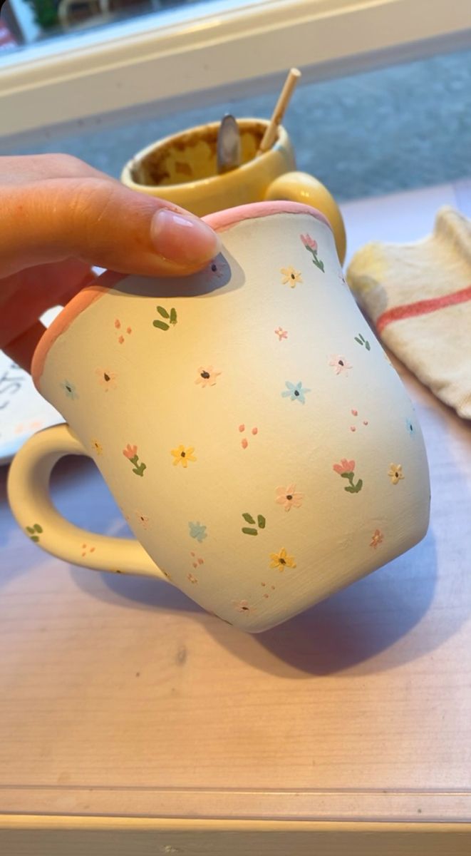 a person is holding a coffee cup on a table