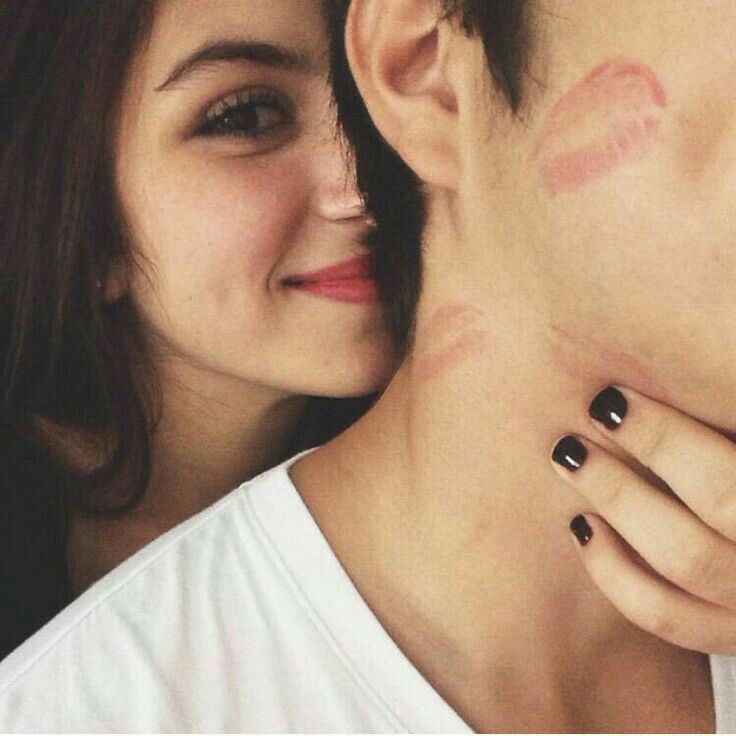 a young man and woman with black nail polishes on their faces are looking at each other